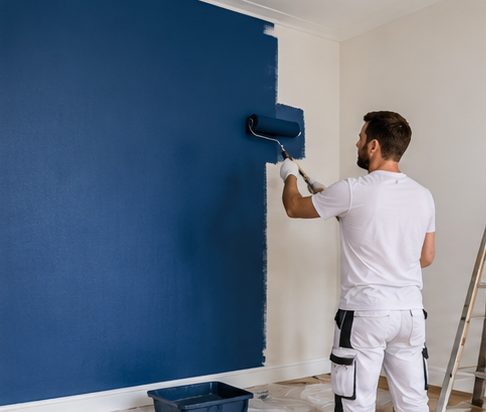 Schilder rolt een muur in donkerblauw