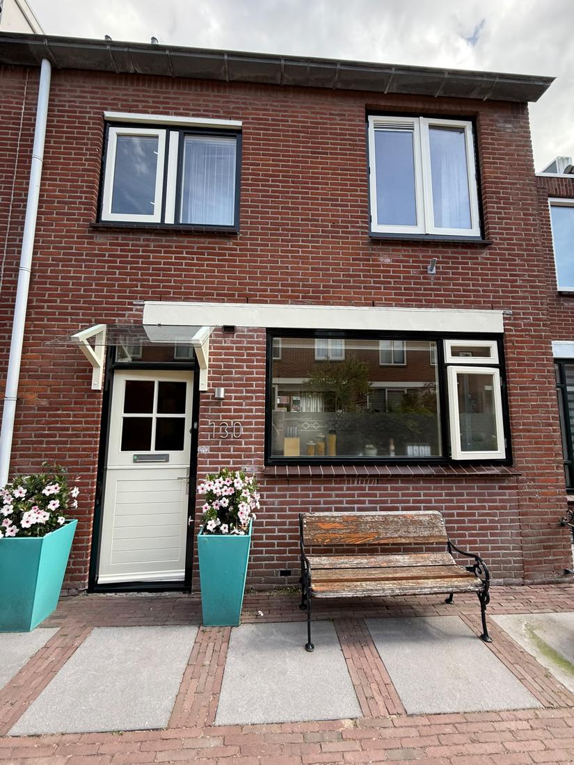 Bakstenen gevel met crèmekleurige kozijnen en voordeur